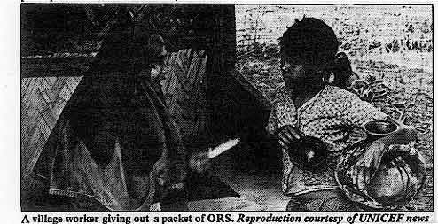 A village worker giving out a packet of ORS.