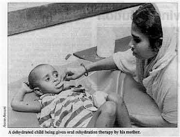 A dehydrated child being given oral rehydration therapy by his mother. 