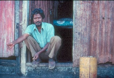 Father sitting in doorway- slide 67 - A Kind of Living